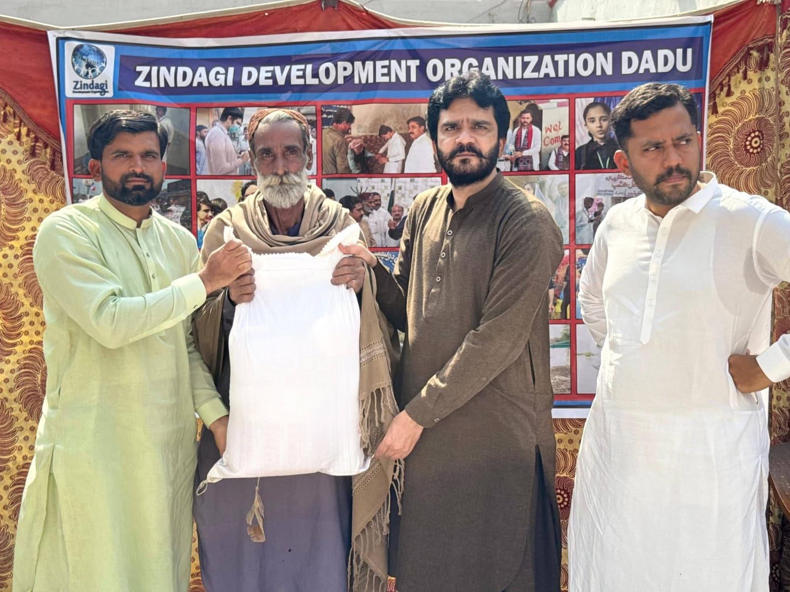 Elderly beneficiary receiving ration bag at ZDO office